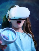Child in VR glasses playing video games