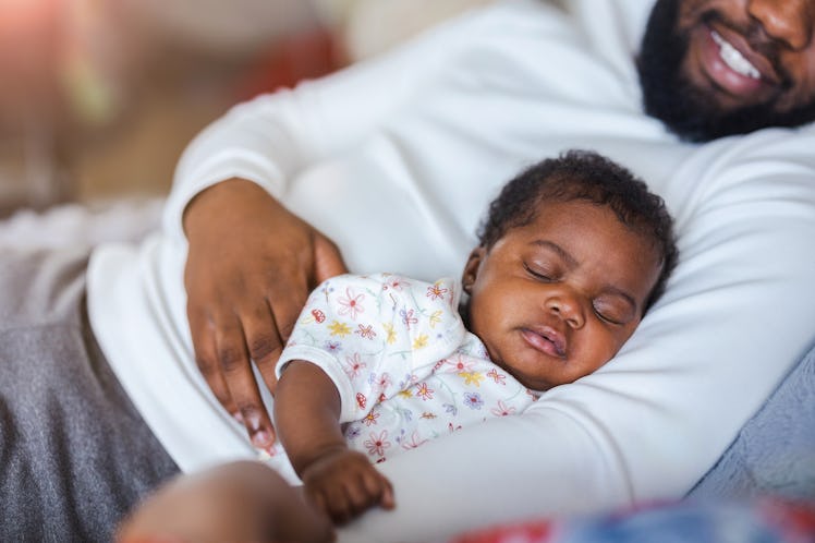Father holding his baby in arms at home