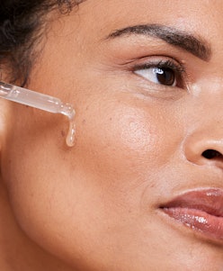 A woman applying a face oil on clean skin. 