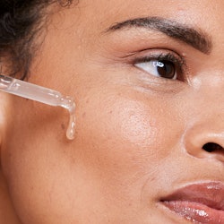 A woman applying a face oil on clean skin. 