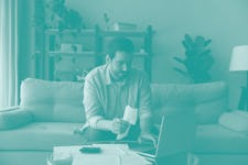 严肃的千禧一代男性在眼镜集中支付水电费,税,租金在线使用…