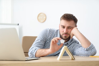 Lazy young office employee procrastinating at workplace