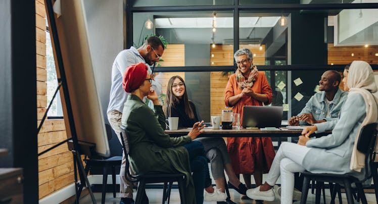 Happy businesspeople smiling cheerfully during a meeting in a creative office.