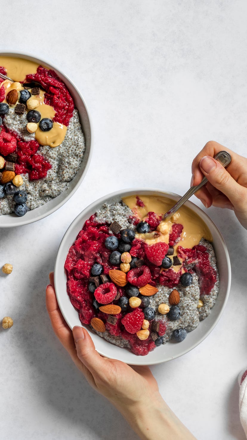 Peanut butter and jelly vegan chia pudding bowl being eaten for breakfast. Made of chia seeds, almon...
