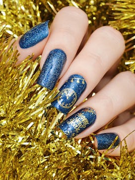 Navy blue nails with gold embellishment, a New Year's Eve nail design. 