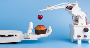Automatization at kitchen. AI technology preparing sweet cupcake with fresh cherry, blue background ...