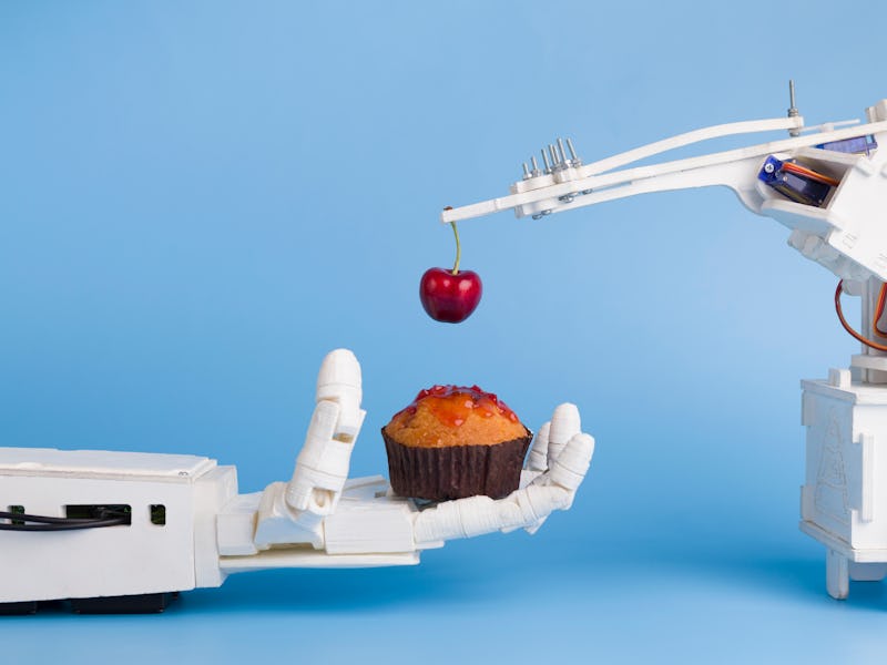 Automatization at kitchen. AI technology preparing sweet cupcake with fresh cherry, blue background ...