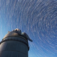 Astronomical observatory under the night sky stars. Blue sky with hundreds of stars of the Milky way...