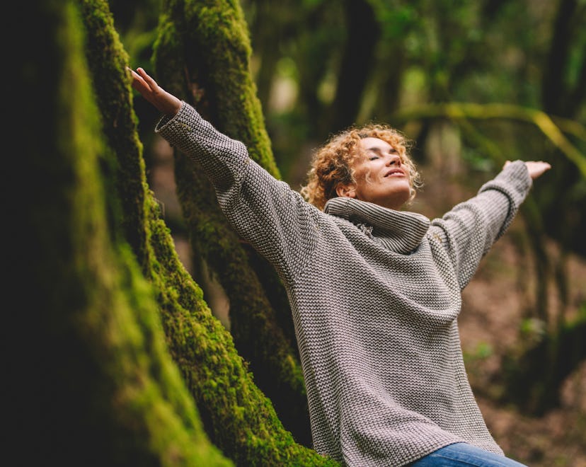 happy woman in a forest because she read her Taurus horoscope 2023