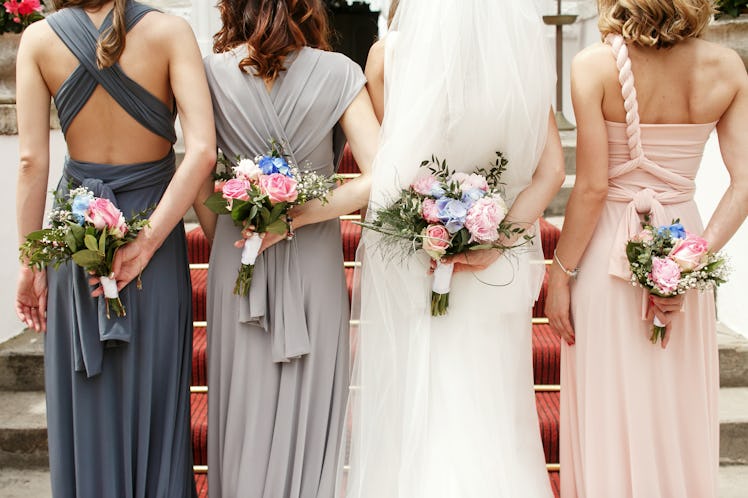 A bride with her bridesmaids wearing dresses they already owned is a 2023 wedding trend. 