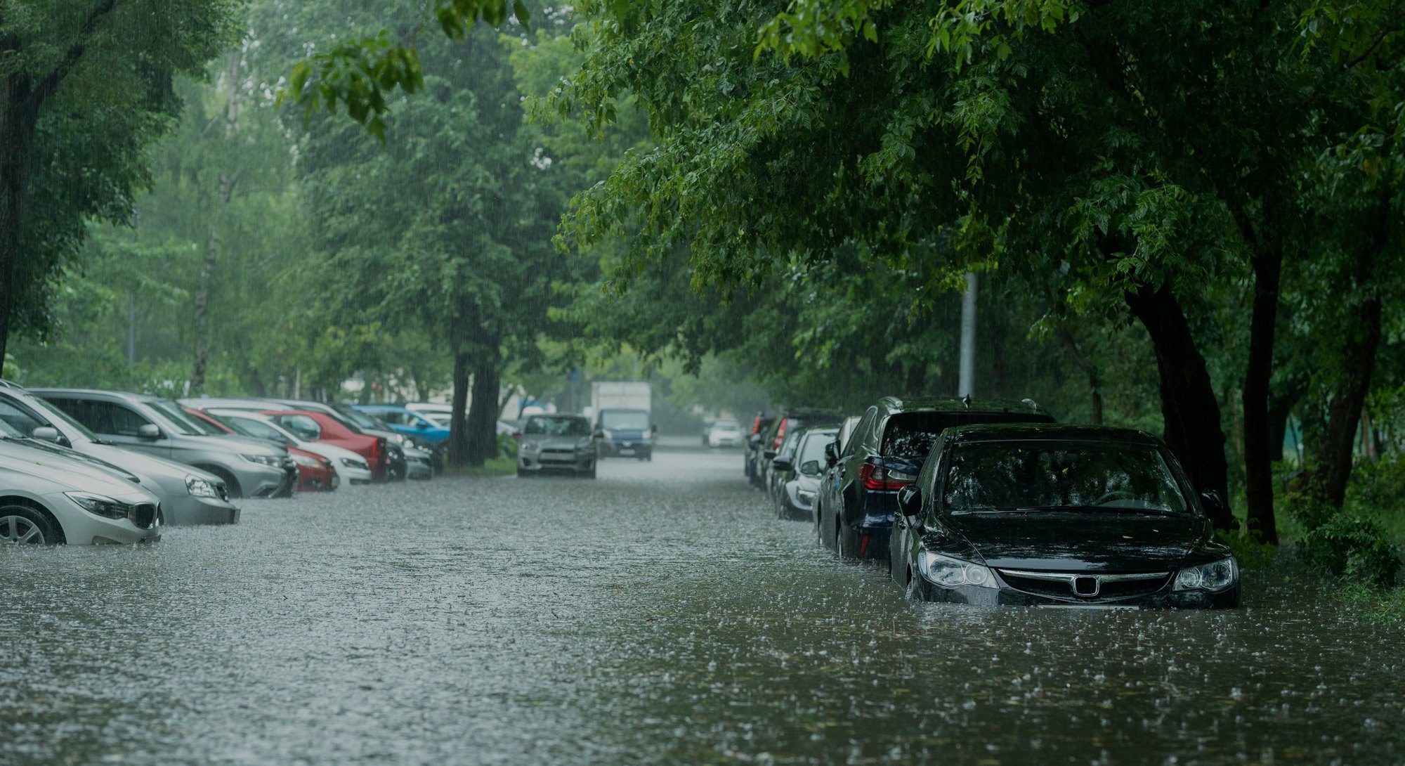 Flooded cars on the street of the city. Street after heavy rain. Water could enter the engine, trans...