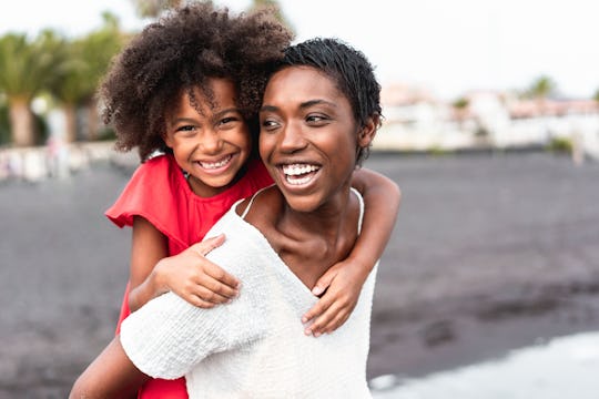 Mother giving her daughter a piggy back ride