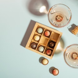 Champagne or wine in elegant glasses, a box of chocolates 