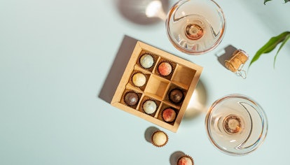 Champagne or wine in elegant glasses, a box of chocolates 