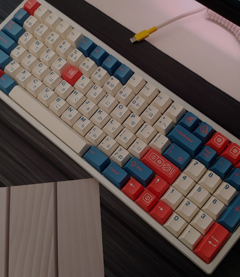 Mechanical keyboard with custom keycaps and custom made USB cable on a desk with deskmat
