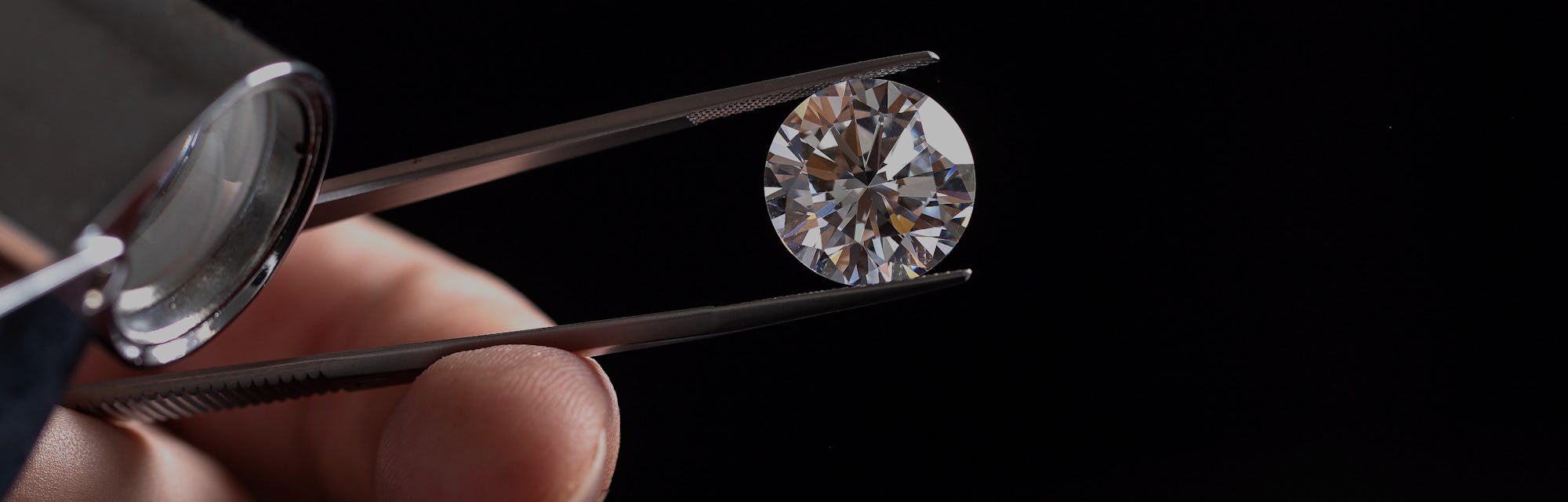 Large polished round cut diamond in hand close up front view. High quality photo