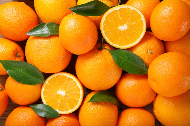 a bunch of fresh oranges with leaves, for romper's story on popular pregnancy cravings