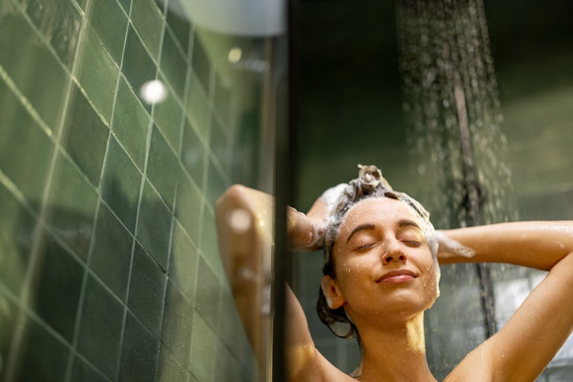 Happy woman with closed eyes in shower