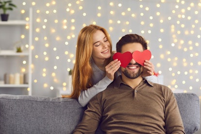 Happy smiling couple in love celebrating their relationship anniversary at home. Young people having...