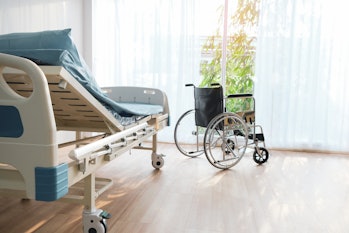 Wheelchair patient bed is in hospital ward.