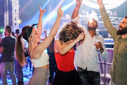 Young friends dancing at a club and buying drinks, which is one of the biggest money conflicts betwe...