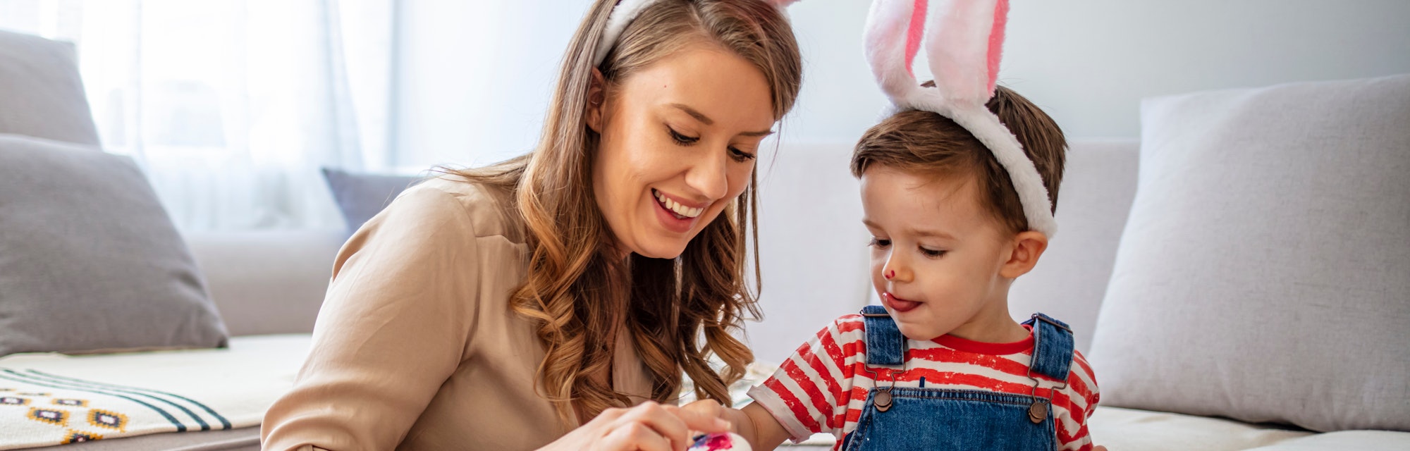 Mother And Son Enjoying Creative Easter Morning, Coloring Eggs. Easter Family Time. Having fun durin...