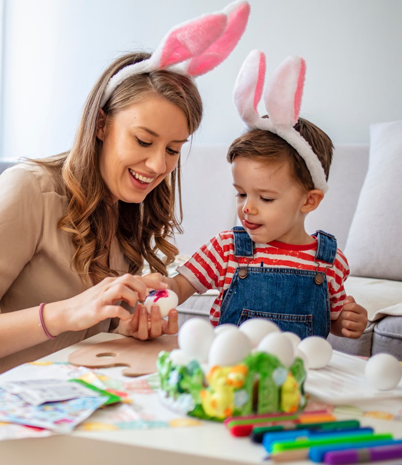 Mother And Son Enjoying Creative Easter Morning, Coloring Eggs. Easter Family Time. Having fun durin...
