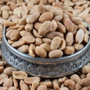 Roasted Peanuts. Peanuts on wood floor. Bulk peanut kernels. Peanuts on a silver plate.