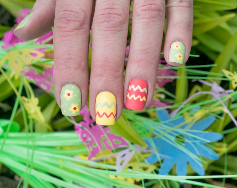 This Easter manicure features spring florals and Easter egg designs.