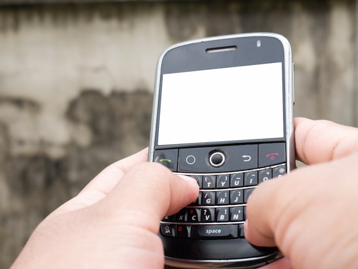 A man typing message on mobile phone with qwerty keyboard. Cellphones with blank display.