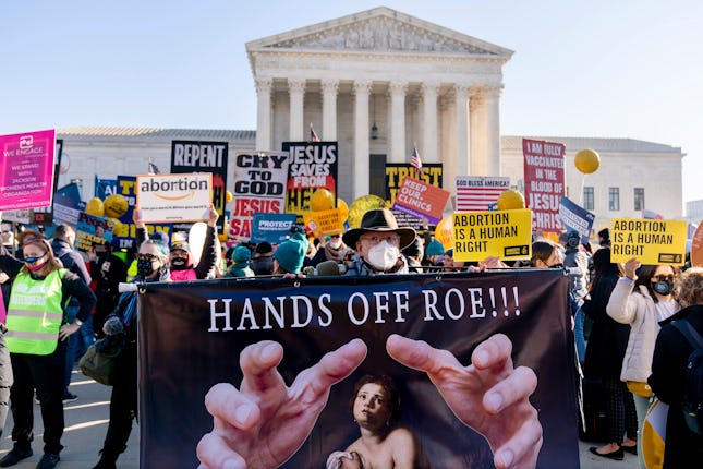Stephen Parlato of Boulder, Colo., holds a sign that reads "Hands Off Roe!!!" as abortion rights adv...