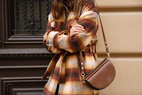 authentic street style portrait of an attractive woman wearing plaid check jacket coat, sunglasses a...