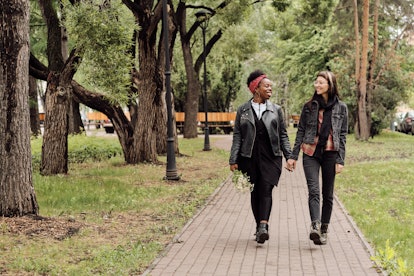 Two women who are in a relationship, walking in a park and holding hands