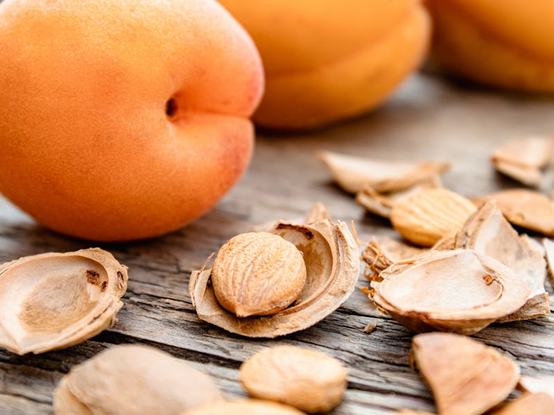 Apricot and apricot seeds on the background of old boards. Apricot pits for the manufacture of table...