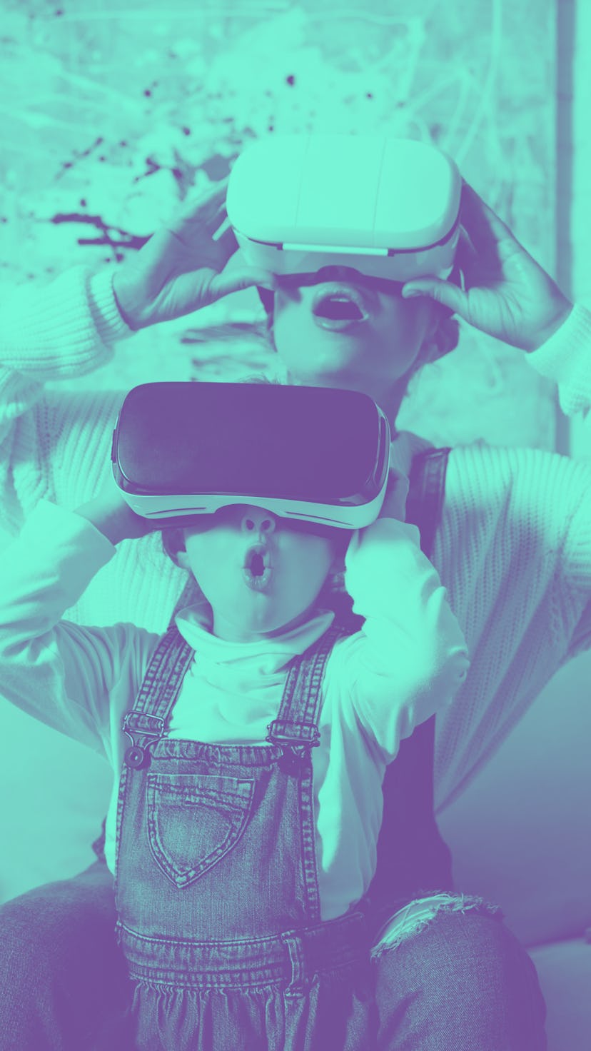 Excited mother and daughter using virtual reality headsets at home