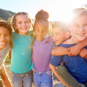 A group of six children playing and laughing outside. A new study shows that Black and Hispanic chil...