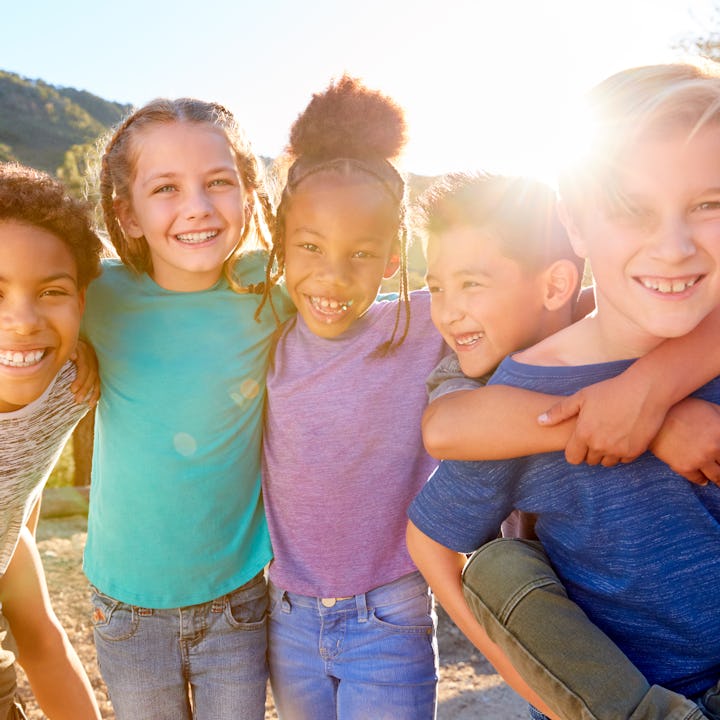 A group of six children playing and laughing outside. A new study shows that Black and Hispanic chil...