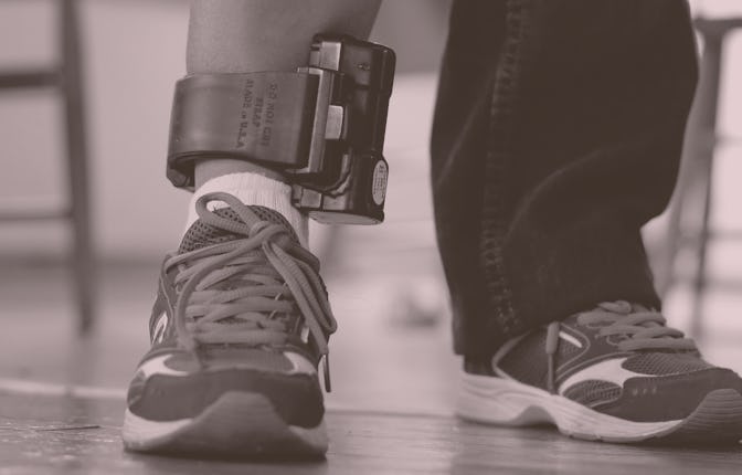 An immigrant from El Salvador that entered the country illegally wears an ankle monitor at a shelter...