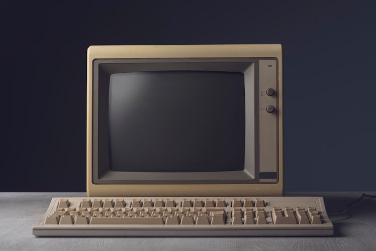 Vintage personal computer with keyboard on a desktop, outdated electronics concept