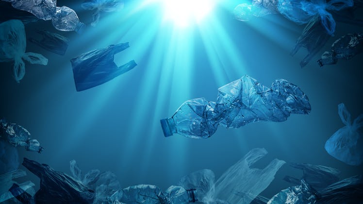 creative background of PET plastic bottles and single-use plastic bags floating in sea or ocean with...