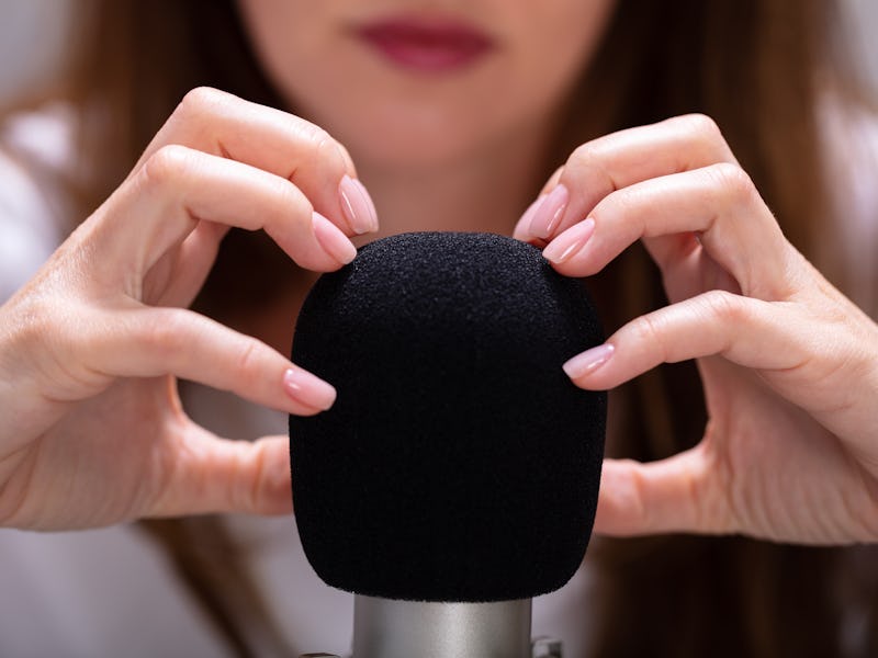 Woman scratching microphone with nails to make ASMR sounds