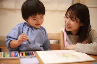 Image of a boy and a nursery teacher drawing