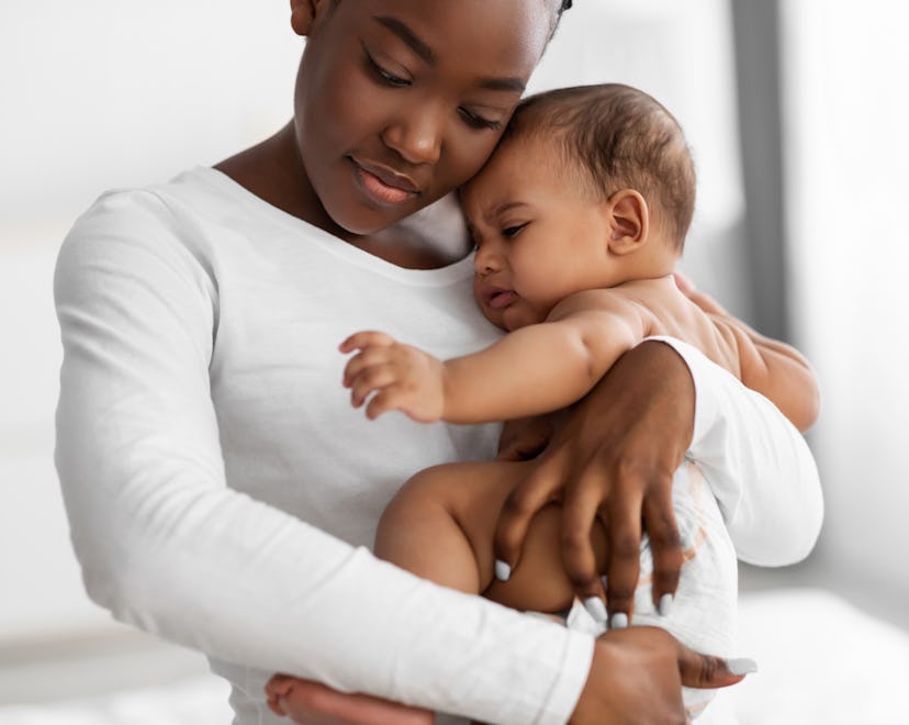 mom holding crying baby, wondering when baby growth spurts happen