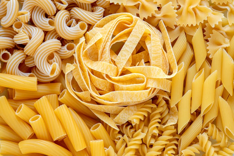 layout of Italian raw pasta, top view, different types and shapes of pasta, durum wheat noodles, clo...