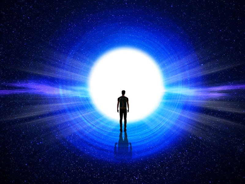 Man silhouette at the end of the tunnel with the universe and blinding light in the background