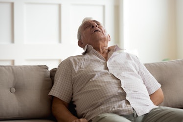 Tired elderly man relax fall asleep on comfortable couch in living room, exhausted mature male take ...