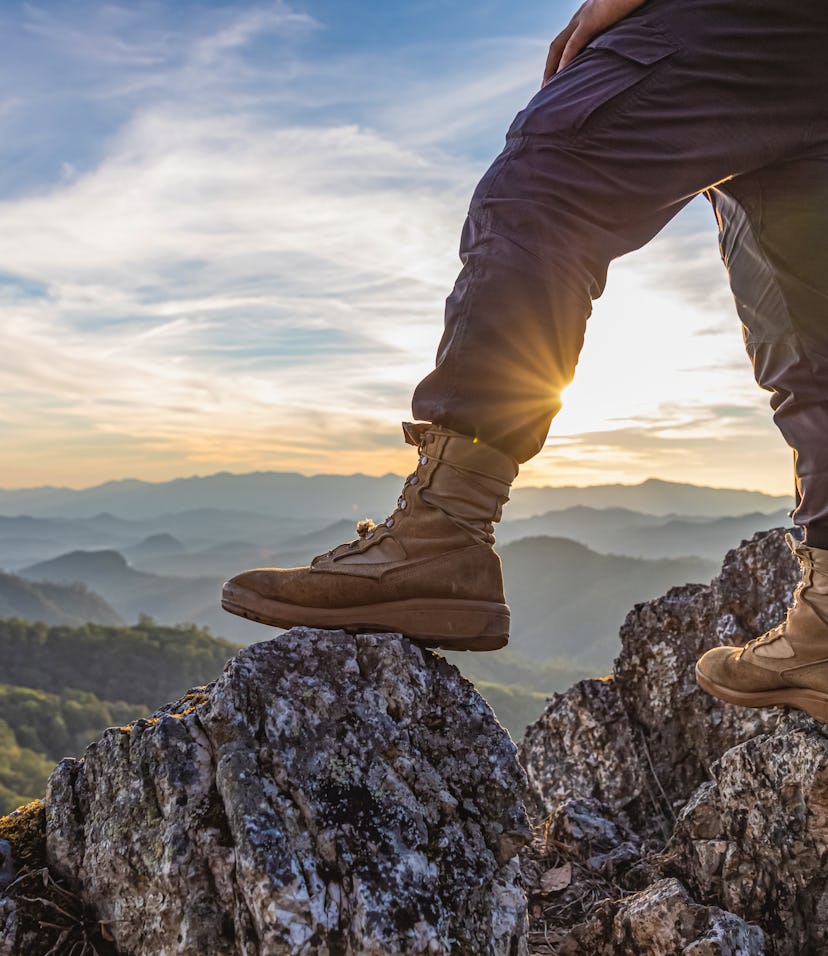 Hiker standing on top mountain sunset background. Hiker men's hiking living healthy active lifestyle...