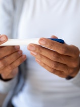 Crop close up of biracial woman hold quick pregnancy test kit check being pregnant. African American...