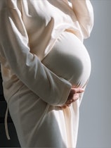 Pregnant Lady standing in diet table wearing white gown