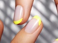 Hands with bright yellow french manicure on geometric background. Nails art design. Close-up of fema...